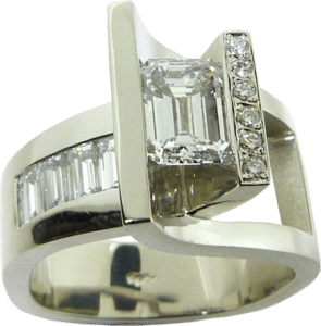 Ring featuring an emerald cut diamond, baguette diamonds, and small round diamond accents