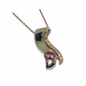 Custom white and rose gold pendant set with a treated pink diamond