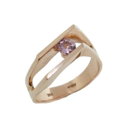 A modern custom designed ring made in 14 karat rose gold showcasing a 4mm round brilliant cut Lotus Garnet. Designed by our jeweler and owner, David Blitt as part of our Studio Tzela line. This piece is perfect to represent January birthdays.
