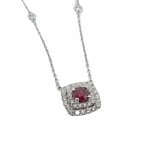 14 karat white gold necklace, showcasing a 0.29 carat round brilliant cut Ruby. Accented with size bezel set chain stations and two halos of diamonds totaling 0.30 carats. This necklace also has a slide adjusting chain. A perfect gift for July birthdays.