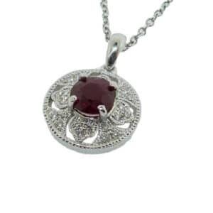 Claw set in a 14 karat white gold antique designed pendant, showcases a 1.01 carat round brilliant cut ruby. Accented with diamonds totaling 0.14 carats. This piece is a perfect gift to represent July birthdays.