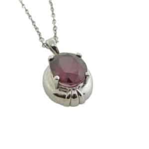 A 14 karat white gold pendant showcasing a 3.96 carat oval shaped Rhodolite Garnet. This piece is perfect to represent January birthdays.