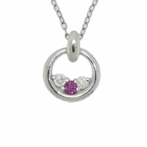 14 karat white gold 3-stone circle pendant, showcasing a 0.12 carat round brilliant cut Ruby and two Hearts on Fire diamonds totaling 0.18 carats. A perfect gift to represent July birthdays.