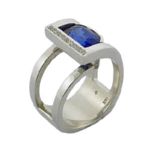 14K white gold custom designed  by Studio Tzela lady's ring set with a 4.11ct oval blue sapphire and accented with 14 pave set ideal cut, round brilliant cut Hearts On Fire diamonds, 0.096cttw.