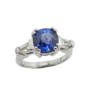 Custom platinum featuring a stunning 2.05ct sapphire in a double claw setting and is accented by 2 = 0.37ctw diamonds.