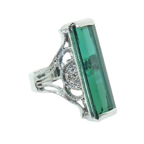 This antique designed fashion ring in 14 karat white gold, has an ornate vintage feel. Showcasing an 8.47 carat elongated emerald cut Green Tourmaline. Accented with six diamonds totaling 0.068 carats. Created by our jeweler and owner, David Blitt as part of our Studio Tzela line. The perfect gift for 8th anniversaries.