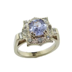 14K white and rose gold custom vintage inspired halo ring by Studio Tzela set with a 1.27ct cushion cut lilac coloured sapphire and accented on the halo with 4 baguette diamonds, 0.22cttw and 18 round brilliant cut diamonds, 0.275cttw.