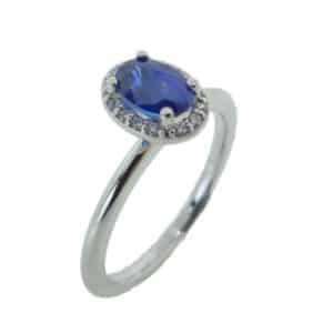 14 karat white gold ring featuring a 0.26ct sapphire and accented by a halo of round brilliant cut diamonds.