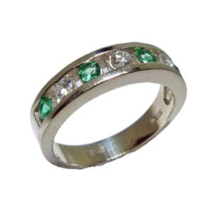 14 karat white gold ring channel set with 4 = 0.21ctw emeralds and 3 = 0.199ctw, G/H, VS-SI, round brilliant cut diamonds. Emerald is the birthstone for May.