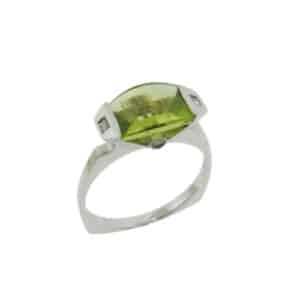 A fun fashion ring in 14 karat white gold, showcasing a 1.95 carat barrel cut Peridot accented with four diamonds. This piece is a perfect gift to represent August birthdays and 20th anniversaries.