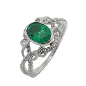 18 karat vintage style ring bezel set with a 0.683 oval emerald and accented with 54 = 0.27ctw round brilliant cut diamonds. Emerald is the birthstone for May.