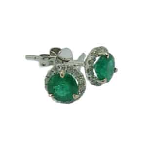 14 karat white gold halo stud earrings set with 2 = 0.753 total carat weight emeralds and 28 = 0.14 total carat weight round brilliant cut diamonds. Emerald is the birthstone for May.