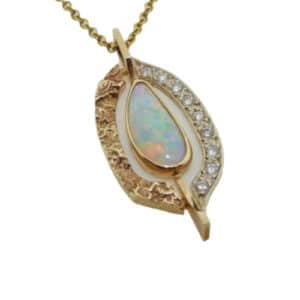14 karat white and yellow gold pendant featuring a 1.18ct opal and accented with 9 = 0.19ctw round brilliant cut diamonds. This pendant is a custom design by David.