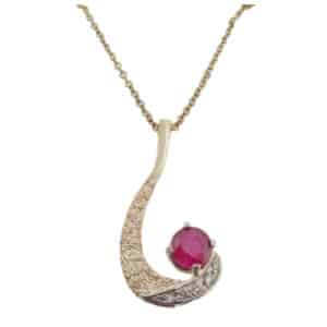 This fun fashion pendant made in 14 karat yellow and white gold, showcases a 1.26 carat round brilliant cut Ruby. Accented with five diamonds totaling 0.09 carats. Created by our jeweler and owner, David Blitt as part of our Studio Tzela line. This unique piece is a perfect gift to represent July birthdays and 40th anniversaries.