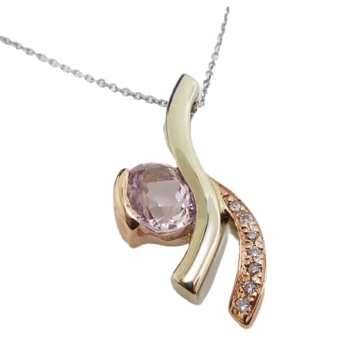 14K white and rose gold custom pendant by Studio Tzela semi-bezel set with an oval 1.443ct pink sapphire and 7 accent diamonds, 0.039cttw.