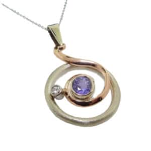 14K white and rose gold custom pendant by Studio Tzela bezel set with a 0.65ct purple sapphire and a bezel set accent diamond, 0.04ct.