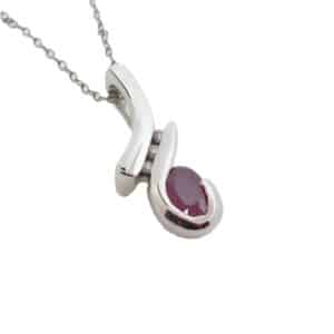 This fun fashion pendant made in 14 karat white gold, showcases a 0.534 carat oval shaped excellent cut Ruby. Accented with three diamonds totaling 0.042 carats. Created by our jeweler and owner, David Blitt as part of our Studio Tzela line. This unique piece is a perfect gift to represent July birthdays and 40th anniversaries.