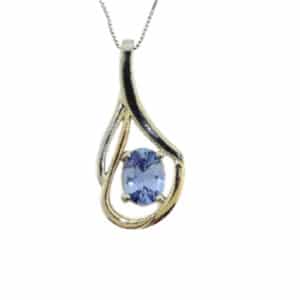 14K white and yellow gold custom pendant by Studio Tzela claw set with a 1.37ct oval light blue sapphire.