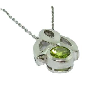 A 14 karat white gold celtic designed pendant, showcasing a round brilliant cut Peridot. A perfect gift to represent August birthdays and 20th anniversaries.