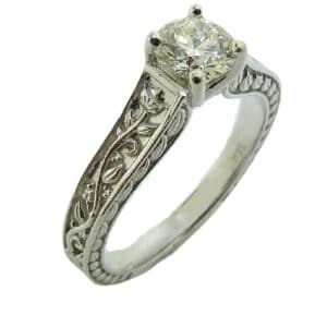 14 karat white gold custom solitaire engagement ring featuring a 0.448ct, E, VS1 round brilliant cut diamond by Hearts on Fire. This unique ring also features beautiful engraving on the band. This ring is a custom design by David.