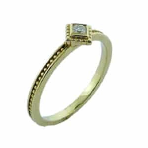14K yellow gold bezel set stackable ring with milgrain detail. Set with one 0.093 carat Dream cut Hearts On Fire diamond