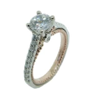 14 karat white and rose vintage design solitaire engagement ring featuring 20 = 0.20ctw round brilliant cut diamonds. This unique design is a great alternative to a traditional solitaire ring. Priced without a center gemstone. Let us find you the perfect center that fits your tastes and budget!