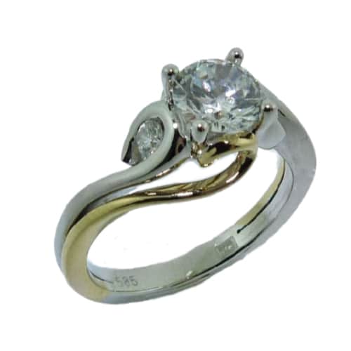 14K White and yellow gold three stone diamond engagement ring by Frederic Sage claw set in the centre with a round 0.75ct Cz and accented on each side within a swirl of polished white gold with 2 channel set round brilliant cut diamonds, 0.11cttw. Available in 14K gold, 18K gold, or platinum. This ring can be made in any combination of white, pink or yellow gold and can be customized to accommodate different size and shape diamonds, by special order.