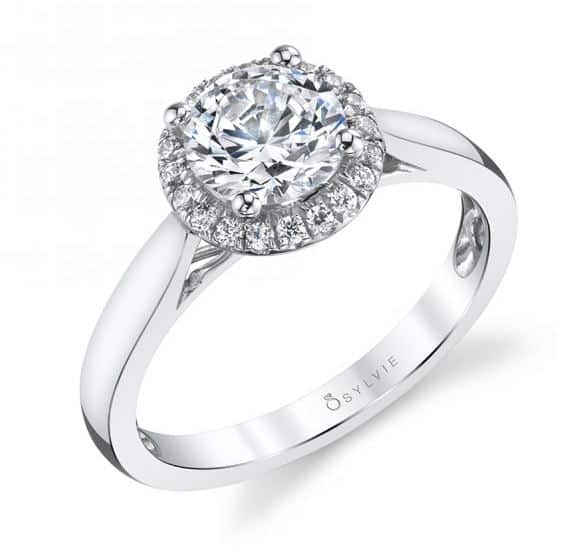 14K white gold Caitlin halo engagement ring by Sylvie Collection featuring 0.13ctw G/H, VS-SI round brilliant cut diamonds. This ring is available with, cushion, round and princess shape centers. A matching band is available. This unique ring is available in 14 or 18K white, yellow and rose gold as well as platinum. Priced without a center gemstone. Let us find you the perfect center that fits your tastes and budget!
