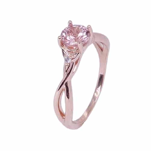 A 14 karat rose gold solitaire ring with celtic twists, showcasing a 0.77 carat round brilliant cut Lotus Garnet. Accented with two diamonds totaling 0.025 carats. This piece is perfect to represent January birthdays and 2nd anniversaries.