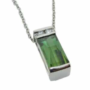 A custom designed pendant in 14 karat white gold. Showcasing a 2.75 carat fancy cut Green Tourmaline. Accented with two diamonds totaling 0.087 carats. Created by our jeweler and owner, David Blitt as part of our Studio Tzela line. The perfect gift for 8th anniversaries.