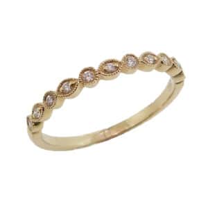 14 karat yellow gold band set with 11 = 0.09ctw , G/H, SI round brilliant cut diamonds. This ring features milgrain engraving and looks stunning by itself or as part of a stack.