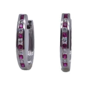 14 karat white gold hoop earrings channel set with 0.18ctw of rubies and 0.13ctw G/H, SI round brilliant cut diamonds. Rubies are the birthstone for July.