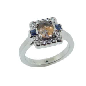 14KW Studio Tzela custom lady's coloured gemstone ring set with a 1.01ct Montana bi-coloured sapphire, accented with 2 bezel set blue sapphires, 0.10cttw and 14 excellent cut, round brilliant cut diamonds, 0.215cttw F/G, SI1
