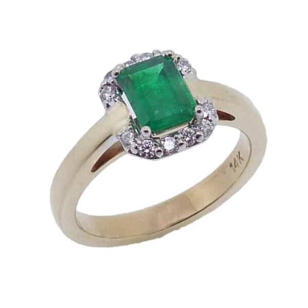 14 karat white and yellow gold halo ring set with a 0.803ct Emerald accented by 12 = 0.144ctw round brilliant cut diamonds. Emerald is the birthstone for May.
