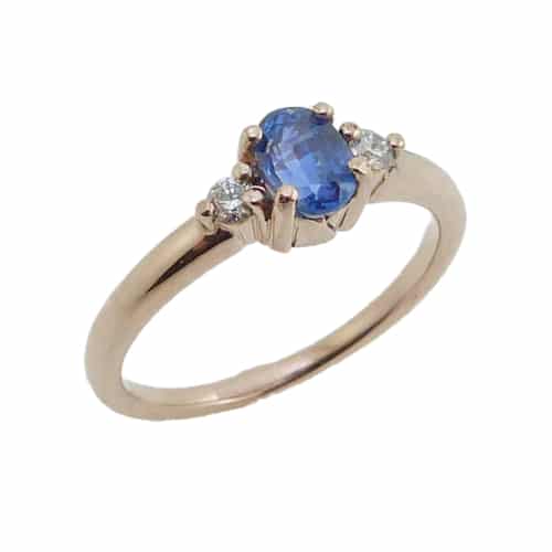 14 karat rose gold ring featuring a 0.618ct oval sapphire accented by 2 = 0.073ct G/H, SI, round brilliant cut diamonds.  Sapphire is the birthstone for September.