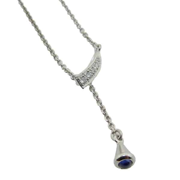 14 karat white gold pendant featuring one 0.10ct cabochon sapphire and accented by 5 = 0.76cttw round brilliant cut diamonds. This pendant is a custom design by Studio Tzela.