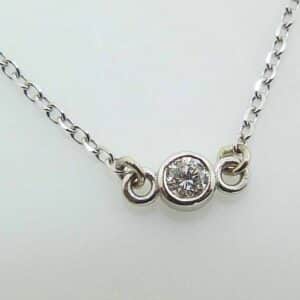 14k white gold pendant and 18" chain bezel set with a 0.065ct H/I, I1 round brilliant cut diamond.