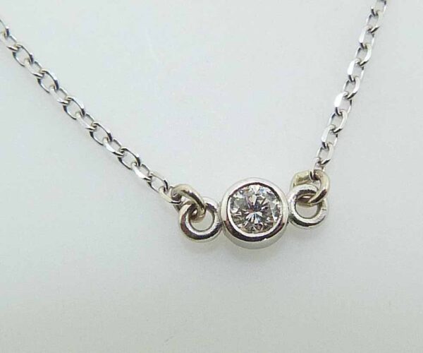 14k white gold pendant and 18" chain bezel set with a 0.065ct H/I, I1 round brilliant cut diamond.