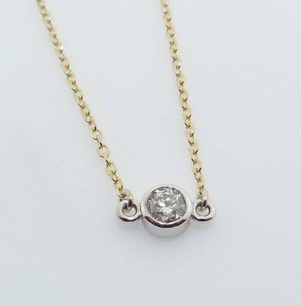 14k yellow gold 18" chain and pendant bezel set with a 0.175ct H/I, I1 round brilliant cut diamond.