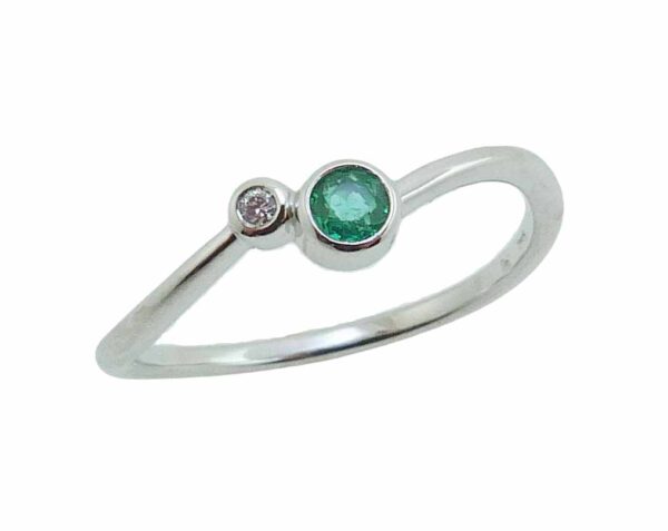 14 karat white gold bypass style band bezel set with a 0.09ct emerald and a 0.014ct G/H, I1 round brilliant cut diamond.  Emerald is the birthstone for May.