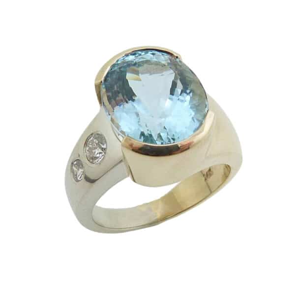 14 karat white and yellow gold ring set with a 7.089ct oval cut Aquamarine and accented by 0.151ct G/H, SI round brilliant cut diamond and a 0.071ct G/H, SI round brilliant cut diamond.  This beautiful ring is a custom Design by David.  Aquamarine is the birthstone for March.