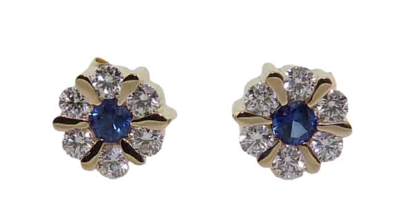 14K Yellow gold earring cluster set with two round blue sapphire totaling 0.19 carats and twelve round brilliant cut diamonds totaling 0.37 carats.
