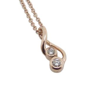 14K rose gold pendant set with 2 round brilliant cut diamonds, 0.06cttw H, SI1-2 on a 14k rose gold adjustable light cable chain.
