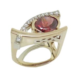 14K White and yellow gold custom Studio Tzela lady's ring set with a 2.34 carat oval rhodolite garnet and 12 very good cut, round brilliant cut diamonds, 0.19cttw, I/J, SI1-2.