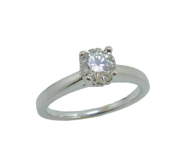 14 karat white gold solitaire engagement ring with a 4 prong head featuring a 0.57ct, I, VS2 round brilliant cut diamond by Hearts on Fire.  This solitaire also features a hidden halo with 0.50cttw G/H, SI1 round brilliant cut diamonds.