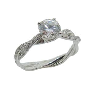 14K White gold engagement ring with pave set diamond twist shank and milgrain detail on the edge. Set with 1 carat round CZ centre and 40 round brilliant cut diamonds, 0.10cttw, G/H, VS-SI. Priced without a center gemstone. Let us find you the perfect center that fits your tastes and budget!