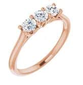 14K Rose gold three stone ring claw set with 3 x 3.5mm round moissanite.