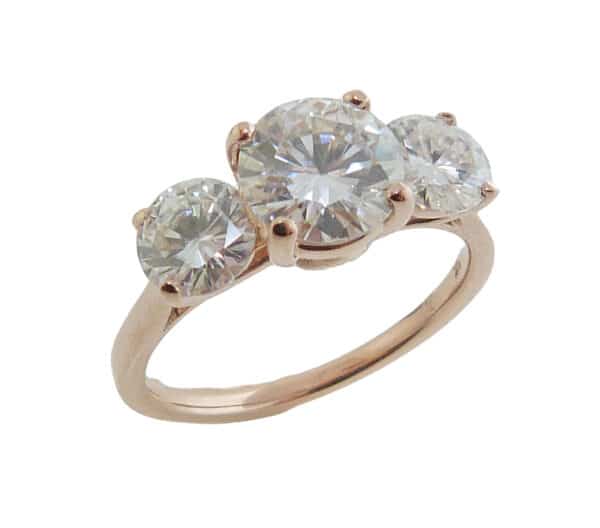 14K rose gold engagement ring claw set with one 6.5 mm and two 5 mm round G-I colour moissanites.