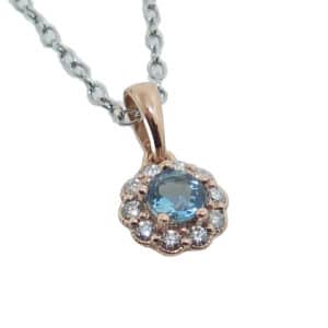 14 Rose gold floral halo pendant set with a 4mm aquamarine and accented with 0.125cttw H, SI1-2, round brilliant cut diamonds. Aquamarine is the birthstone for March.