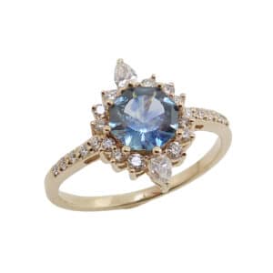 14K yellow gold lady's custom halo ring set with a 0.89 carat octagon Montana Sapphire and accented on the band and halo with 24 round brilliant cut and pear shape diamonds, 0.352 total carat weight, H-I, SI.